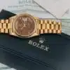 Rolex Day-Date 36 18038 angled dial view on blue pillow showing walnut burl dial with day window and cyclops date