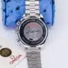 Omega Speedmaster Racing 3517.30.00 side profile on blue ostrich pillow showing chronograph pushers and case thickness