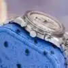 Omega Speedmaster Racing 3517.30.00 full watch front view on blue ostrich pillow showing checkered dial chronograph layout and steel bracelet