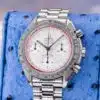 Omega Speedmaster Racing 3517.30.00 angled dial view on blue pillow showing checkered silver dial with orange minute track