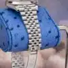 Rolex Datejust 41 stainless steel Jubilee bracelet links on blue ostrich pillow showing five-piece link construction and polished center