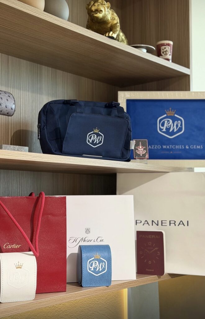 Panerai box and passport, Cartier and H. Moser & Cie. packaging, and Palazzo Watches & Gems pouches on the Jersey City showroom shelf